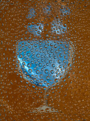 Translucent balls are located against the brown background with blue silhouettes of a wine glass and hearts. Abstract fantasy. 3D render.