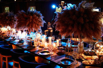 The served table in the luxury restaurant. Dark wooden table, beautiful evening restaurant with luxury rustic decor