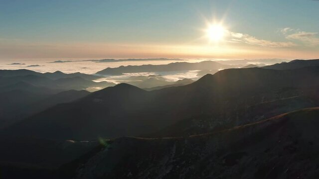 Mountains landscape aerial drone view. Flying over beautiful foggy mountains at sunrise.