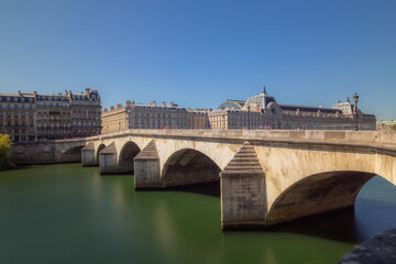 Fototapeta premium The Pont du Carrousel leading to the Louvre over the River Seine on a cleary sunny day in Paris, France