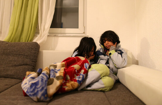 Two brothers from Iraq Hsan and Hubas watch cartoons in their temporary home in a village near Velika Kladusa