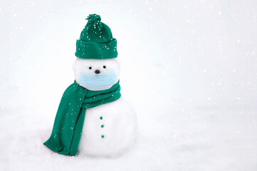 Snowman wearing a face mask, winter hat. scarf on a white background