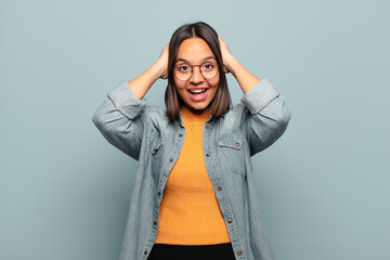 young hispanic woman looking happy, carefree, friendly and relaxed enjoying life and success, with...