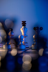 Chess board with chess pieces on blue background. Concept of business ideas and competition and strategy ideas. White king and queen close up.