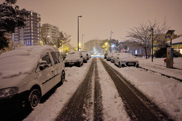 Obraz premium Street of a city at night on a snowy day.