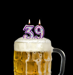 number 39 candle in beer mug for birthday celebration isolated on black 