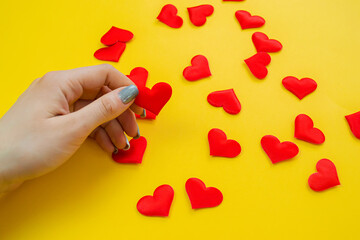 Hands on a yellow background with a heart, love. Selective focus.