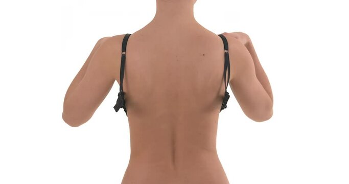Back view of unrecognizable Caucasian woman taking of her bra. Isolated on white background.