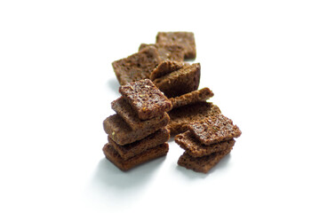 Black bread crackers lie on a white background
