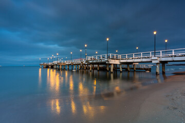 Illuminated pier in Brzezno on the winter beach at dusk, Gdansk.  Poland. © Patryk Kosmider