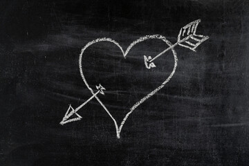 Fototapeta na wymiar Heart symbol with arrow on chalk board, love symbol.