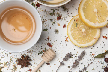 Herbal tea, top view. Dry herbs, lemon slices and tea cups on white. Herbs in bulk, zero waste and eco-friendly lifestyle, herbal medicine concept.
