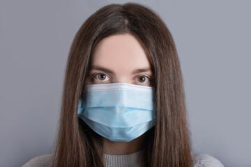 Close-up portrait of woman girl teenager her she nice attractive lovable cute adorable winsome girl with long dark hair wear white sweater protection flu cold facial medical mask over gray background