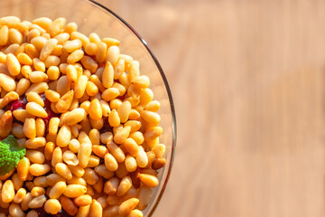 Delicious dessert with lingonberry and pine nuts in a glass close up in a restaurant. The background is blurred