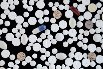 Pharmaceutical medication and pills on a black surface