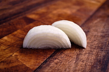 finely chopped raw onions in a plate on a brown wooden background. view from above