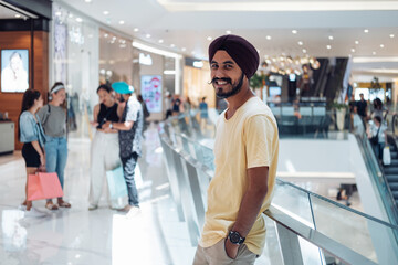 Portrait of handsome Indian man looking at camera in shopping mall
