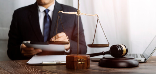 Justice and law concept.Male judge in a courtroom with the gavel, working with, computer and...