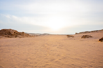 Fototapeta na wymiar sand dunes and stones in the desert of Egypt at sunset with blue sky
