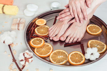 pedicure and manicure in the spa salon with sliced oranges, cinnamon and cotton
