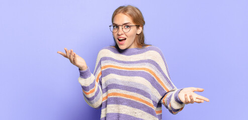 blonde pretty woman feeling extremely shocked and surprised, anxious and panicking, with a stressed...