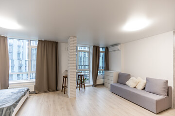 Stylish scandinavian living room with design furniture, plants, wooden desk. wooden parquet. Nice apartment. Modern decor of bright room