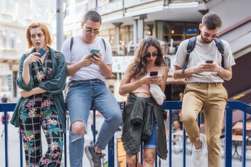 Group of friends using smartphones together. Young people addiction to new technology trends. Youth, new generation internet friendship concept. Emotional isolation and depresion