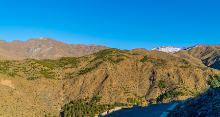 Amazing panorama view of dry mountainous landscapes in the High Atlas mountain range in Morocco with snow-capped peaks