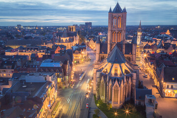 Fototapeta na wymiar The beautiful historic old town of Ghent, Belgium at night after sunset during blue hour and the Saint Nicholas' Church.
