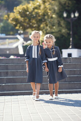 Charming little girls in retro dress walking in town on a sunny summer day