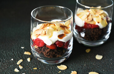 Dessert black forest with cherries in a glass on a dark green background. Traditional German dessert. Horizontal focus.