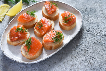 Bread toast with butter and salmon for a snack. Breakfast. Fish canapes on the table.