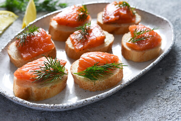 Bread toast with butter and salmon for a snack. Breakfast. Fish canapes on the table.