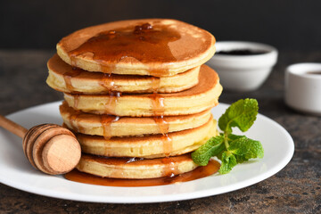 Pancakes with maple syrup and mint on the kitchen table. Breakfast.