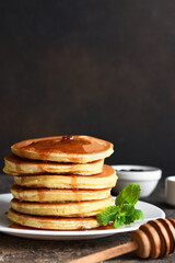 Pancakes with maple syrup and mint on the kitchen table. Breakfast.