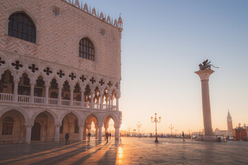 Fototapeta na wymiar Early morning sun rays beam through arches of the Doge's Palace in St. Mark's Square in Venice, Italy.