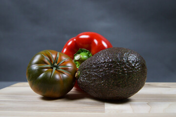 Various vegetables on a wooden kitchen board.