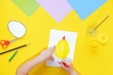 DIY and kids creativity. Step by step instruction: Create an Easter card with chicken. Childrens handmade Easter craft. Top view Step 6. draw the chicken's legs with a red felt-tip pen