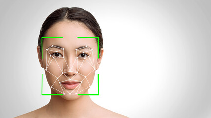 The concept of a face recognition system on a white background is to copy the space. Futuristic and technological scanning of the face of a beautiful Asian woman. scan a person for the security servic