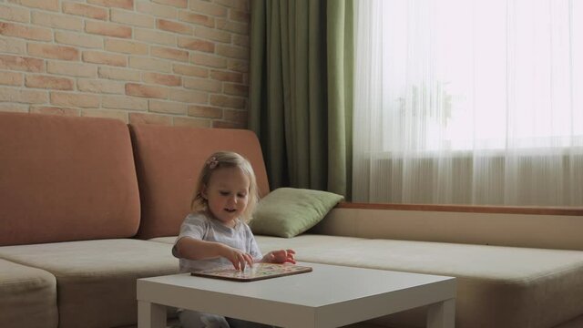 Little girl playing puzzel with numbers on the table. Figures. Medium shot.