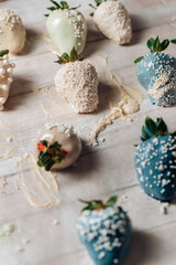 Fototapeta na wymiar Tasty Blue and white chocolate dipped strawberries with sugar sprinkles on wood background