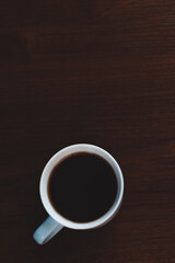 cup of coffee on wooden table in dark light mode