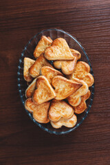 homemade heart shape cookies on a glass plate on a wooden background with film grain effect
