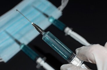 Corona virus Covid-19 vaccine in injection syringe on black. Coronavirus vaccination concept during...