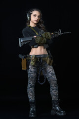 A girl with rifles in her hands on a black background