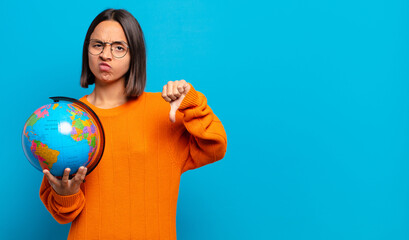 young hispanic woman feeling cross, angry, annoyed, disappointed or displeased, showing thumbs down...