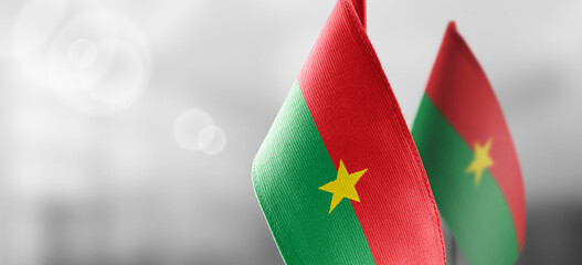 Small national flags of the Burkina Faso on a light blurry background