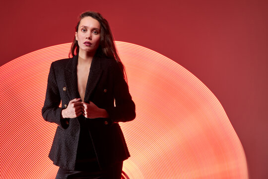 brunette female model in red color light painting, isolated background. creative photo, freezelight concept