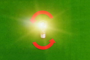 Electric light bulb, two rounded red arrows on a green background. The concept of a business idea. Thinking.