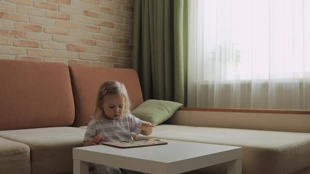Little girl playing puzzel with numbers on the table. Figures. Medium shot.